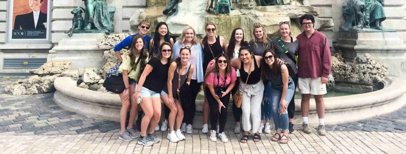 Students posing in front of a fountain.