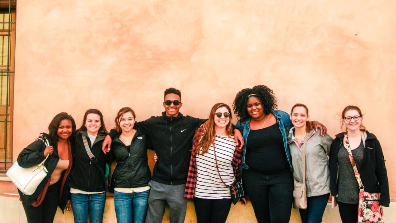 Students posing in front of a wall.