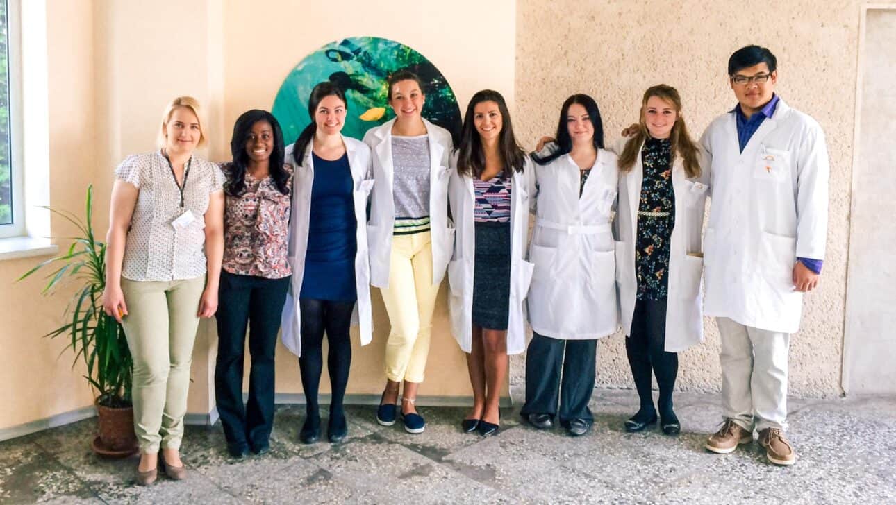 Students standing in a line in white coats.