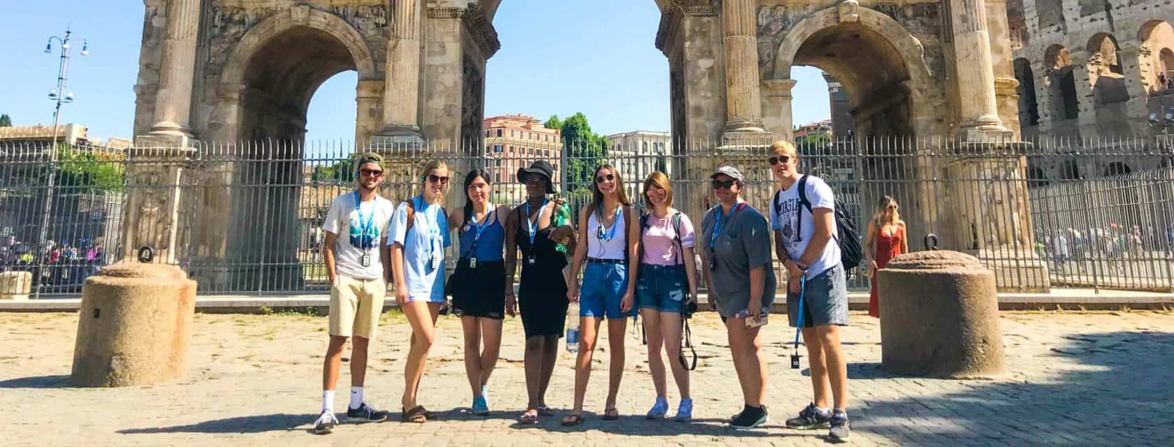 Atlantis students in front of a landmark arch.