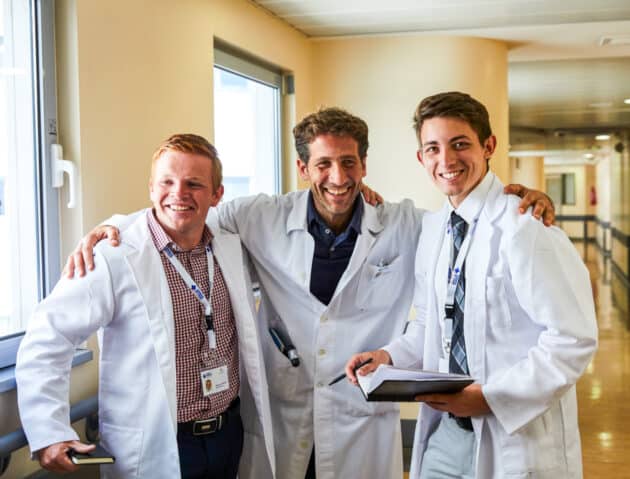 Students smiling with a doctor in the hospital.