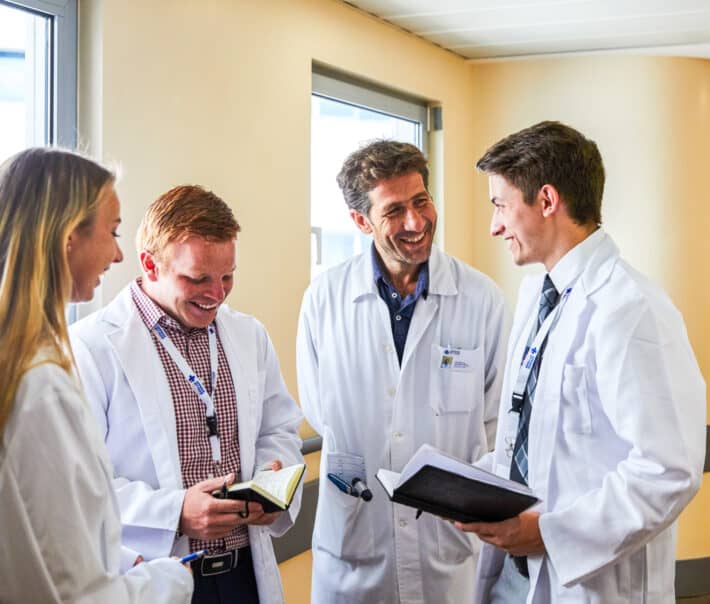 Students speaking to a doctor while shadowing.