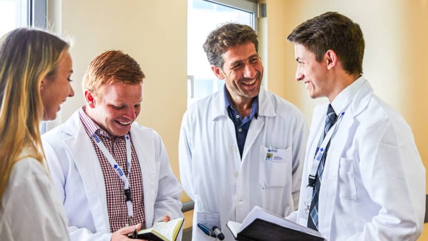 Students speaking to a doctor while shadowing.