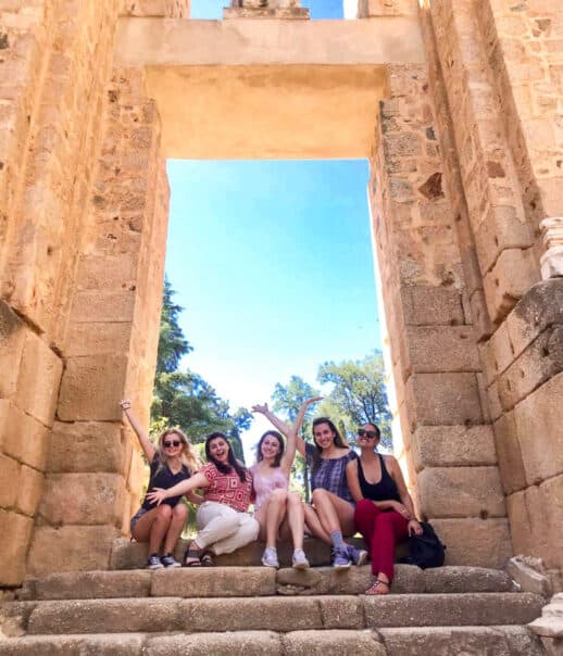 Students sitting in an archway posing for the camera.