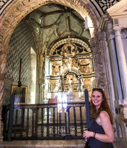 A student standing by an ornate window in a church.