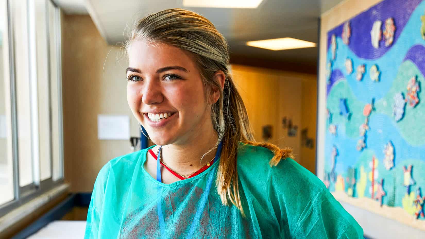 A student smiling in a wing of the hospital.