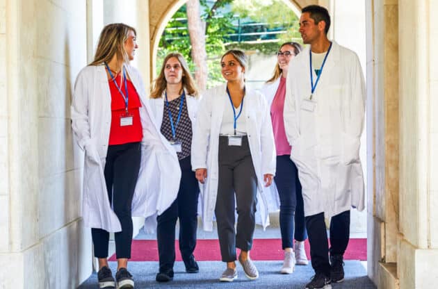 Students walking through the hallway of the hospital where they are shadowing.