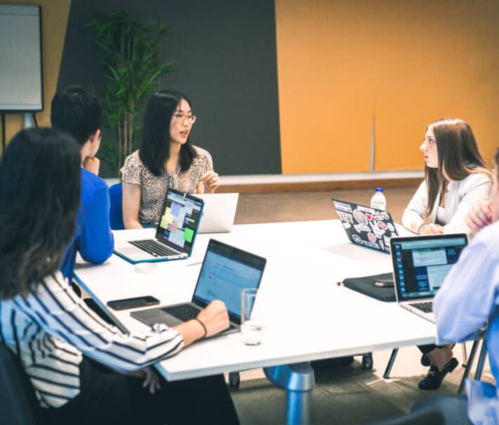 Students sitting around a table having a discussion.