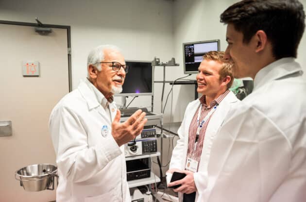 Two students getting the opportunity to speak with a doctor while shadowing.