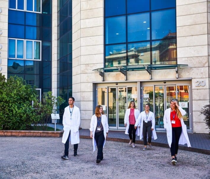 Students walking out of the entrance of the hospital.