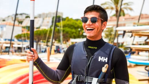 A student smiling and learning how to kayak.